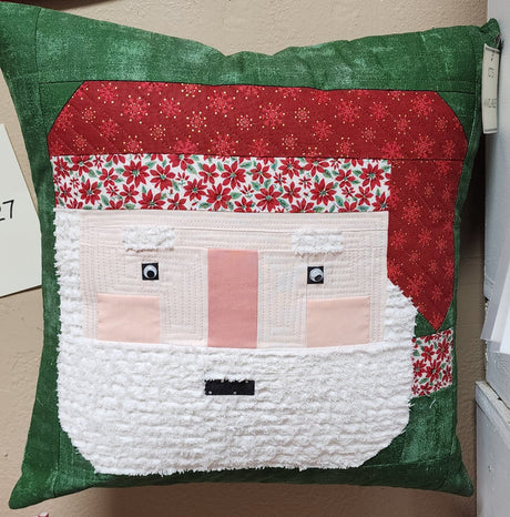 Completed Sew Jolly Santa Christmas Pillow Kit with green, red, and white patchwork fabrics and a textured white beard